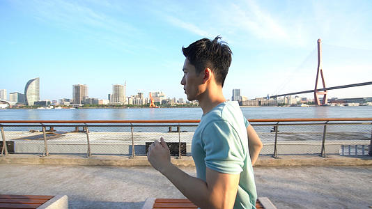 男青年沿着江边跑步视频的预览图