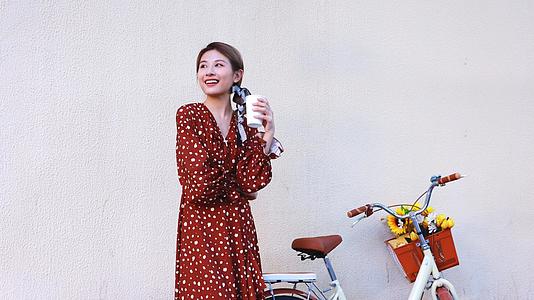 骑行的女青年在路边喝咖啡视频的预览图