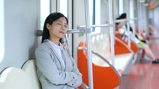 4k地铁里困倦疲乏休息的通勤女性视频的预览图
