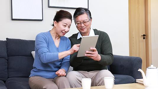 幸福的一对老年夫妻看平板电脑视频的预览图