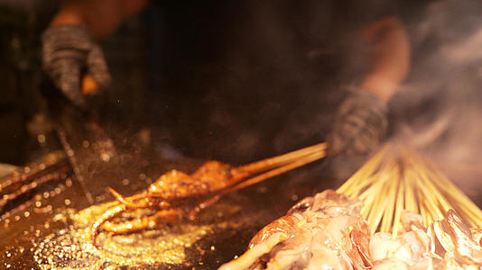慢镜头升格拍摄城市夜晚烧烤海鲜鱿鱼串4k素材视频的预览图