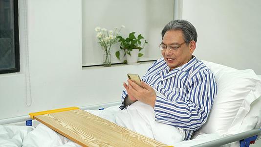 坐在病床上的老人使用手机视频的预览图
