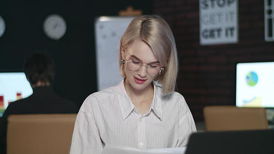 深思熟虑的商业女性在黑暗办公室的笔记本电脑上阅读文件视频的预览图