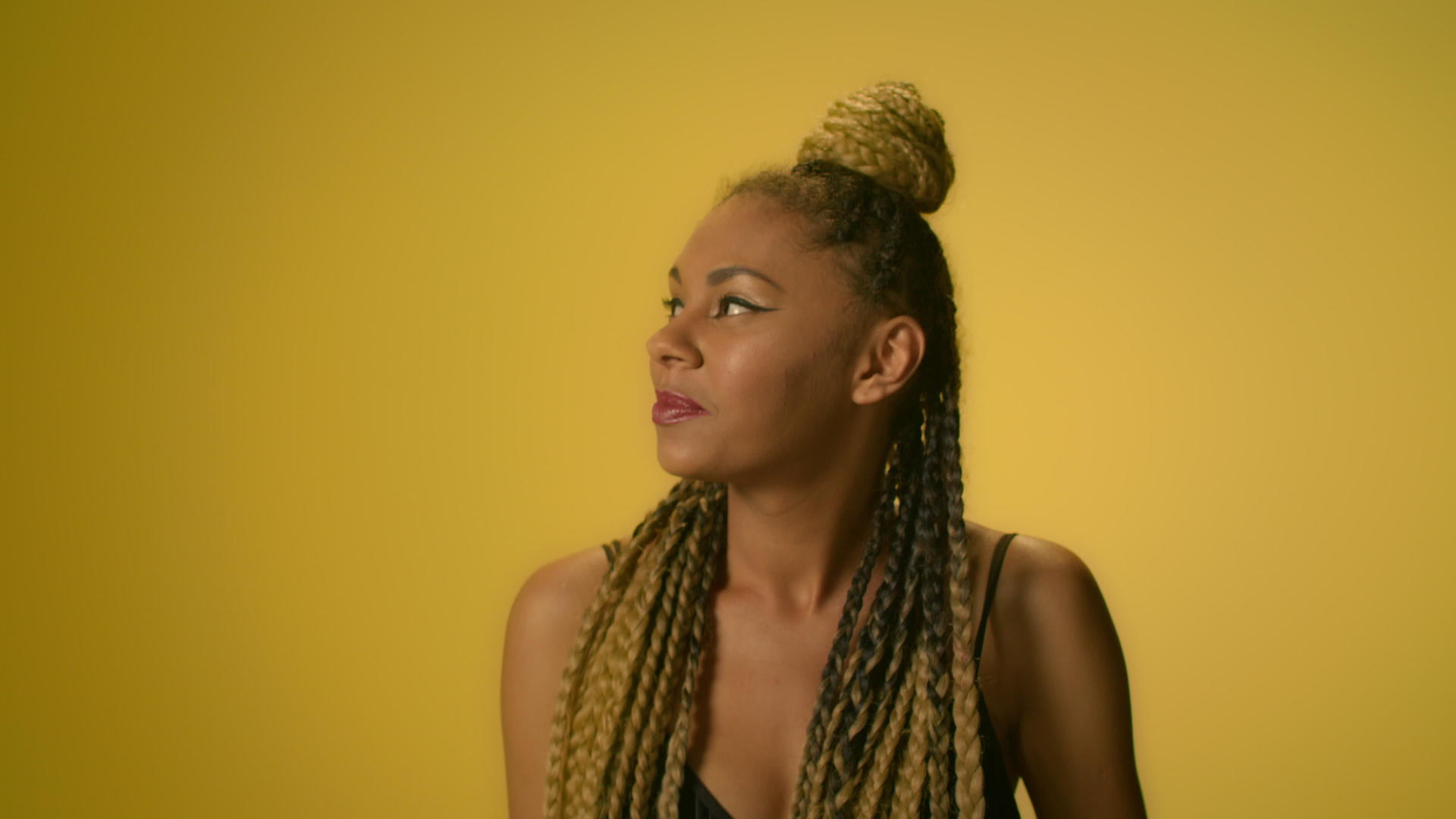 在非洲扎脏辫的美国女人在黄色上跳舞视频的预览图