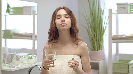 女孩洗澡后喝水吃药视频的预览图