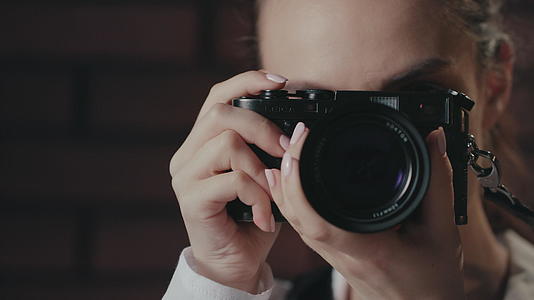 年轻的女摄影师用相机拍照视频的预览图