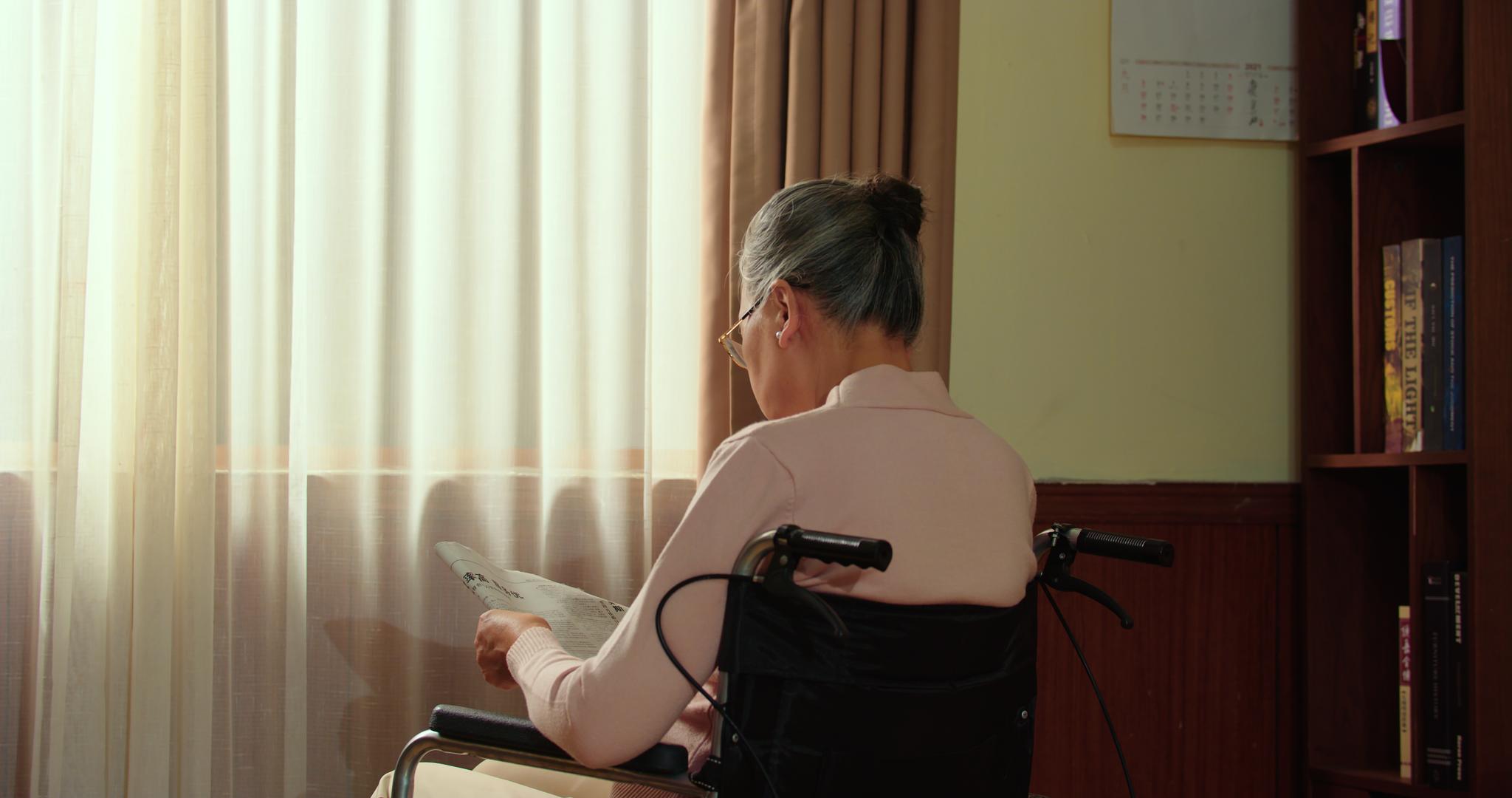 8K轮椅上看报纸的孤独老人视频的预览图