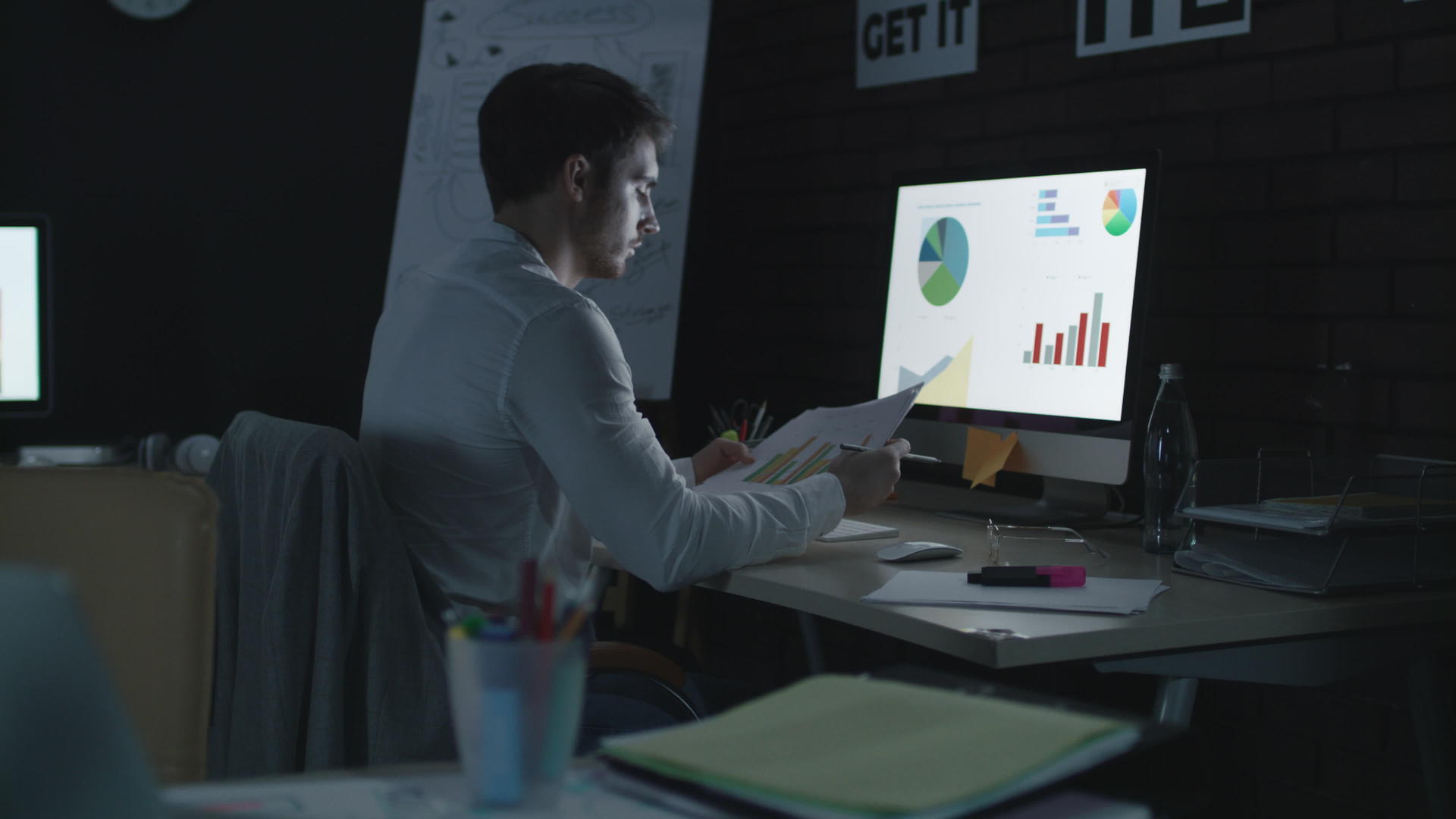 在夜间办公室工作的超负荷商人分析财务图表视频的预览图