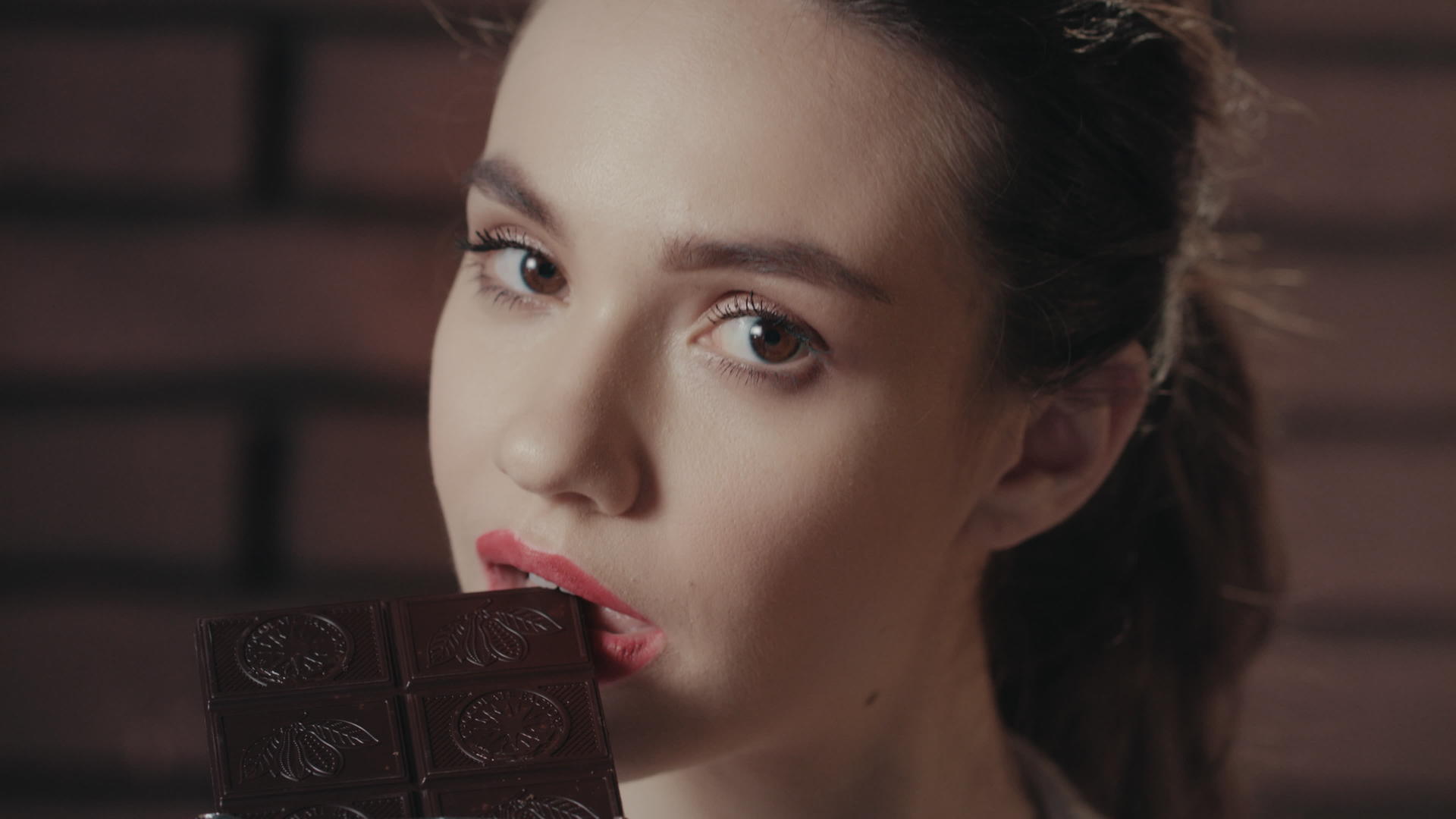 迷人的女人咬黑巧克力视频的预览图