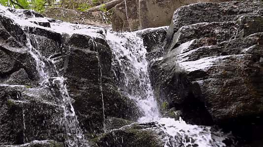 山里岩石之间的流水视频的预览图