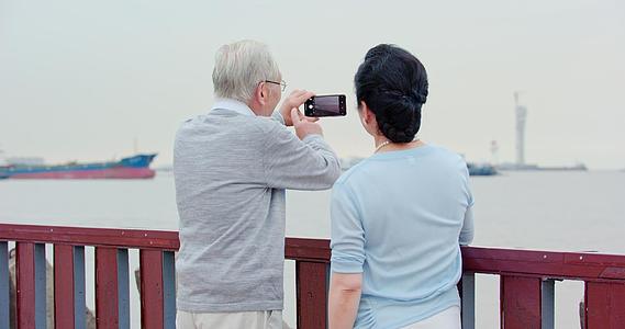 海边正在拍照的老人视频的预览图