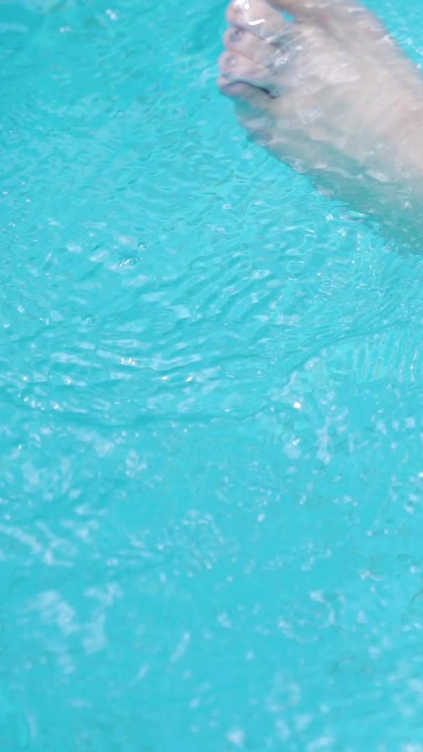 游泳池女孩的脚搅动水花波纹视频的预览图