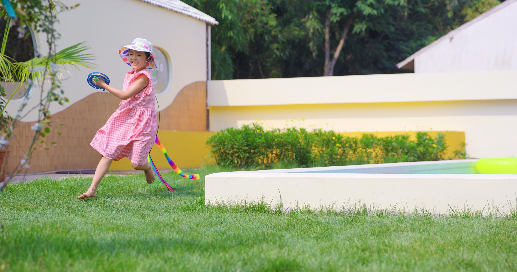8K可爱小女孩院子里放风筝跑动视频的预览图