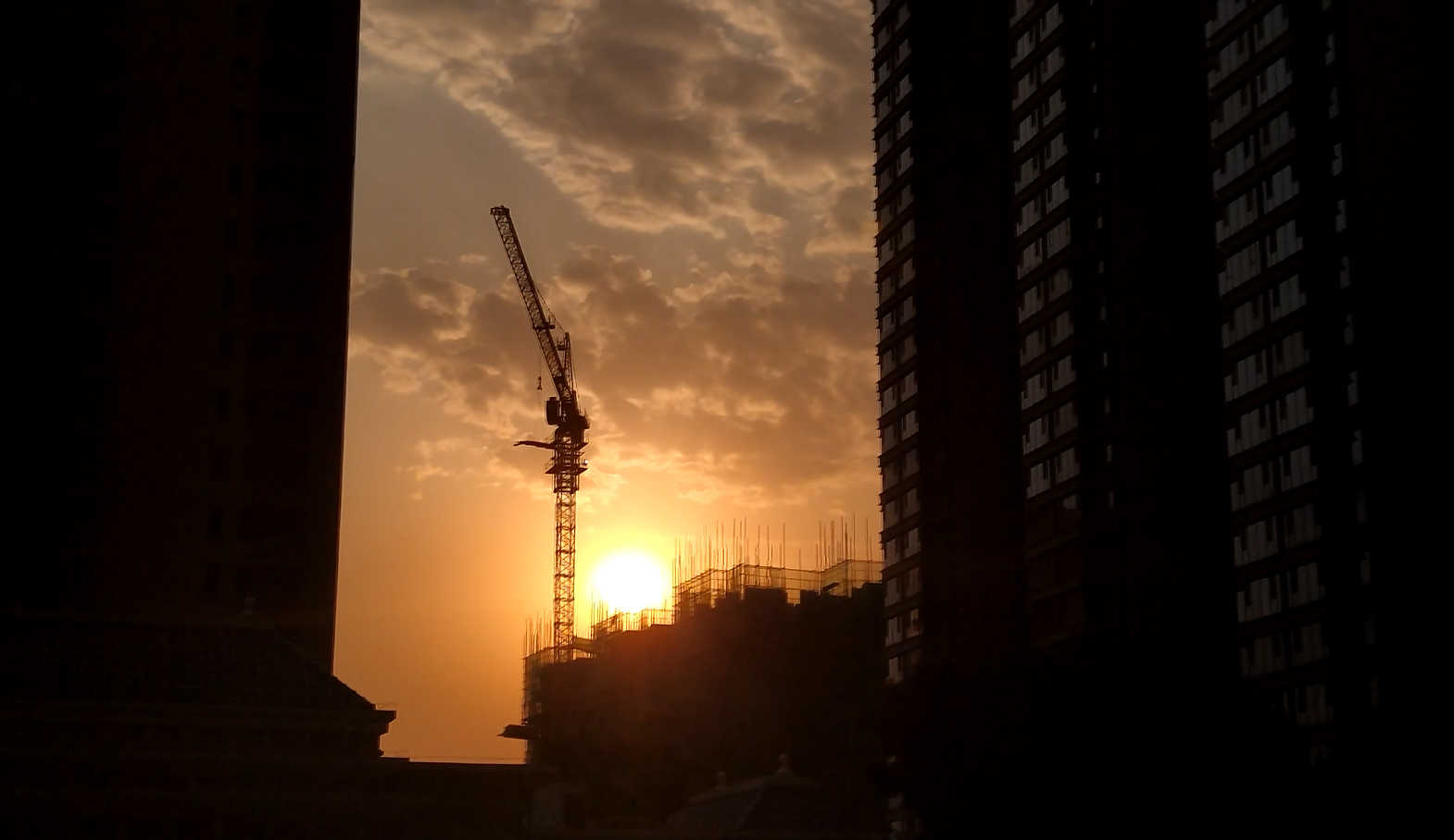4k实拍大楼建筑夕阳下塔吊工作视频视频的预览图