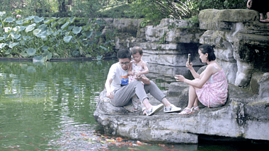 公园池塘边一家三口快乐的生活实拍素材温馨视频的预览图