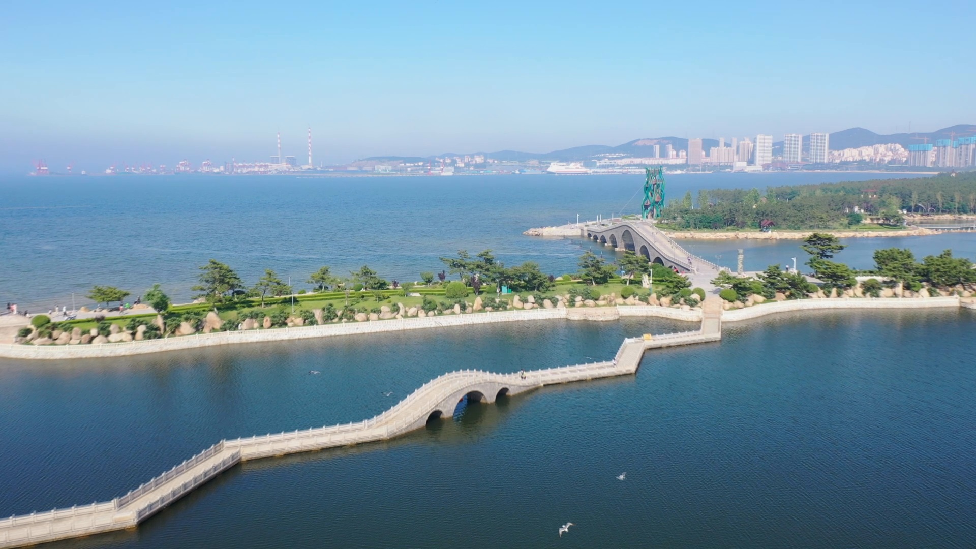 海边公园拱桥航拍美景视频的预览图