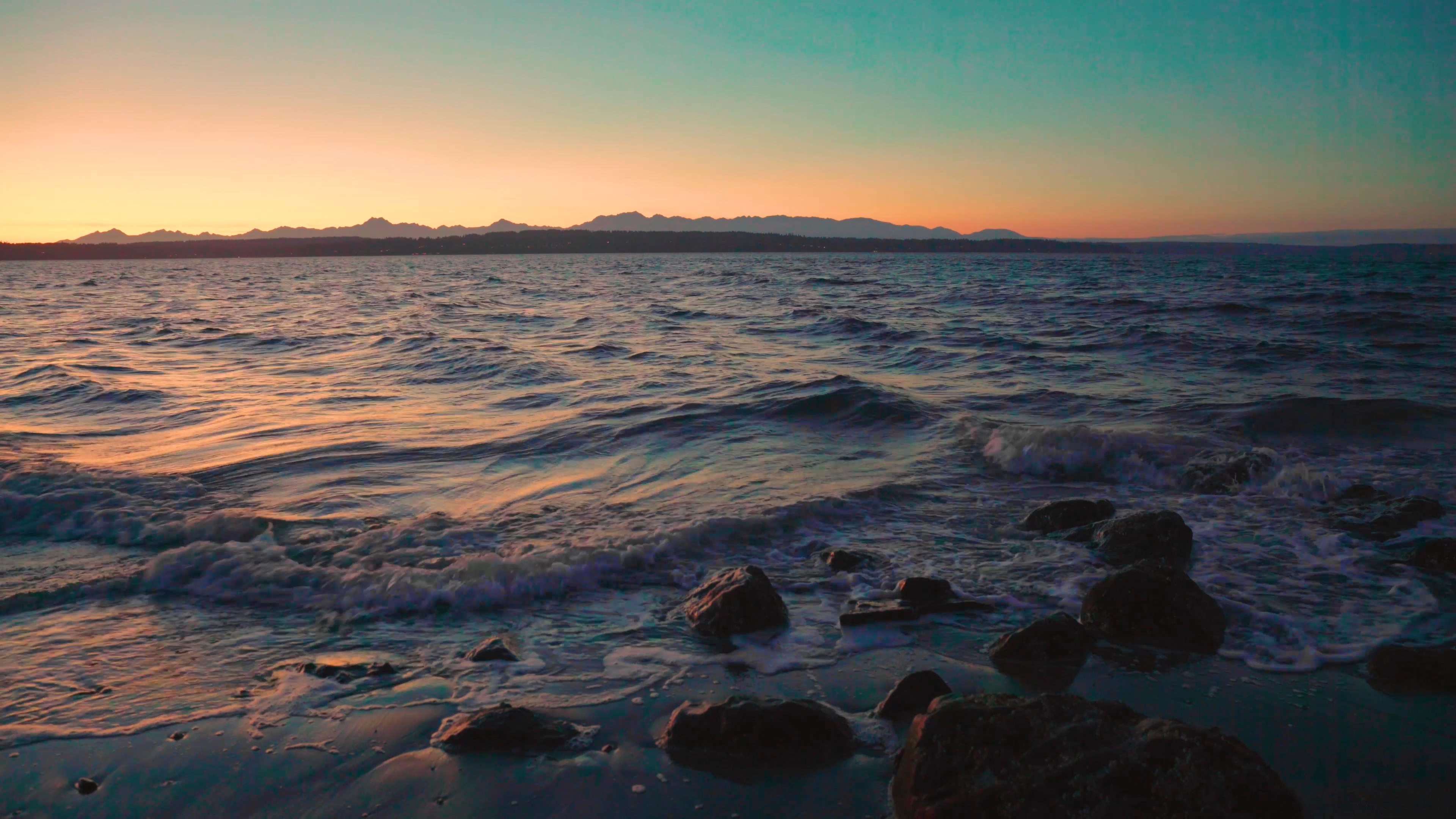 4K夕阳下的浪花拍打礁石视频的预览图