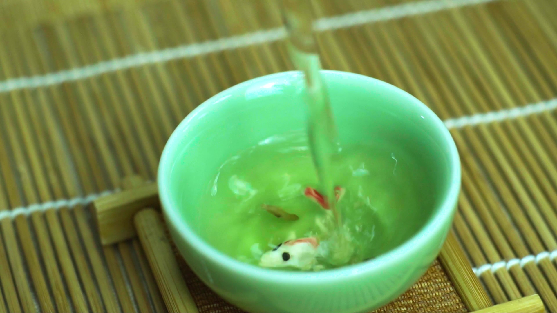 4K实拍茶客倒茶入杯金鱼在茶中视频素材视频的预览图
