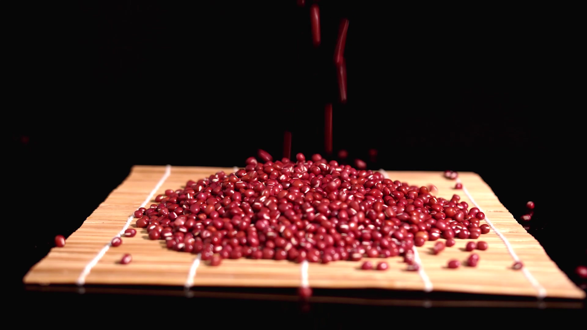 4K实拍红豆洒落在竹席上视频素材视频的预览图