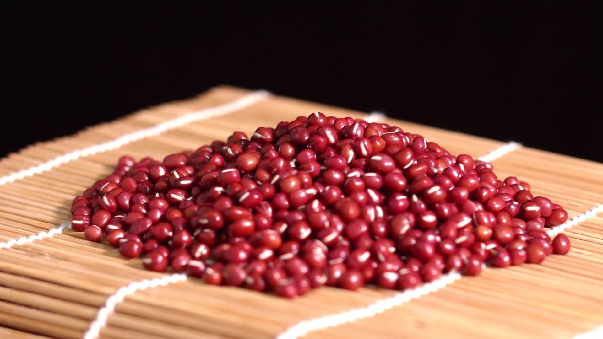 4K实拍红豆放在竹席上展示视频素材视频的预览图
