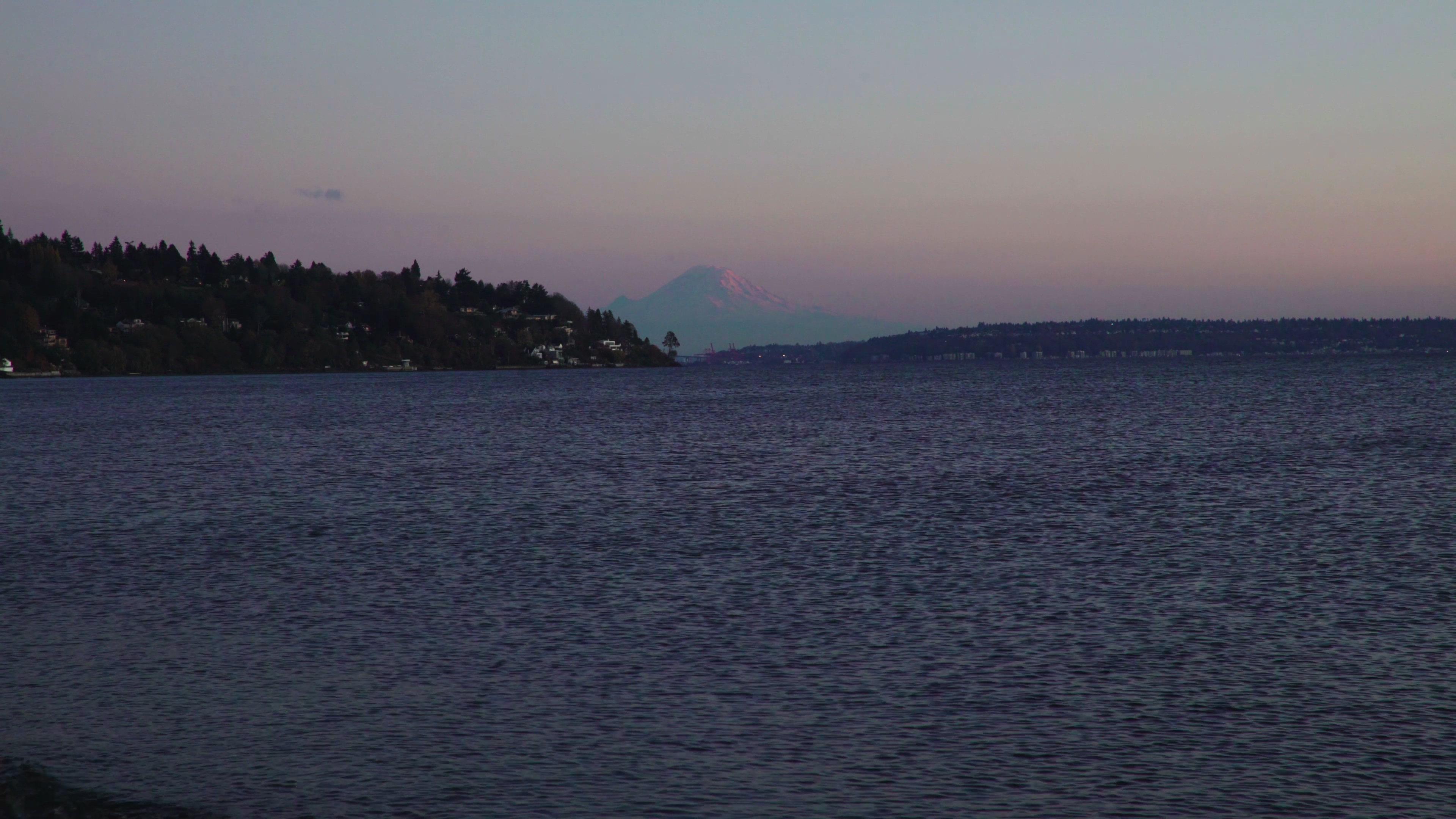 4K夕阳下海边远眺彼岸的雪山视频的预览图