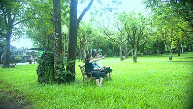 4K实拍坐在公园大树下的中年夫妇聊天视频的预览图