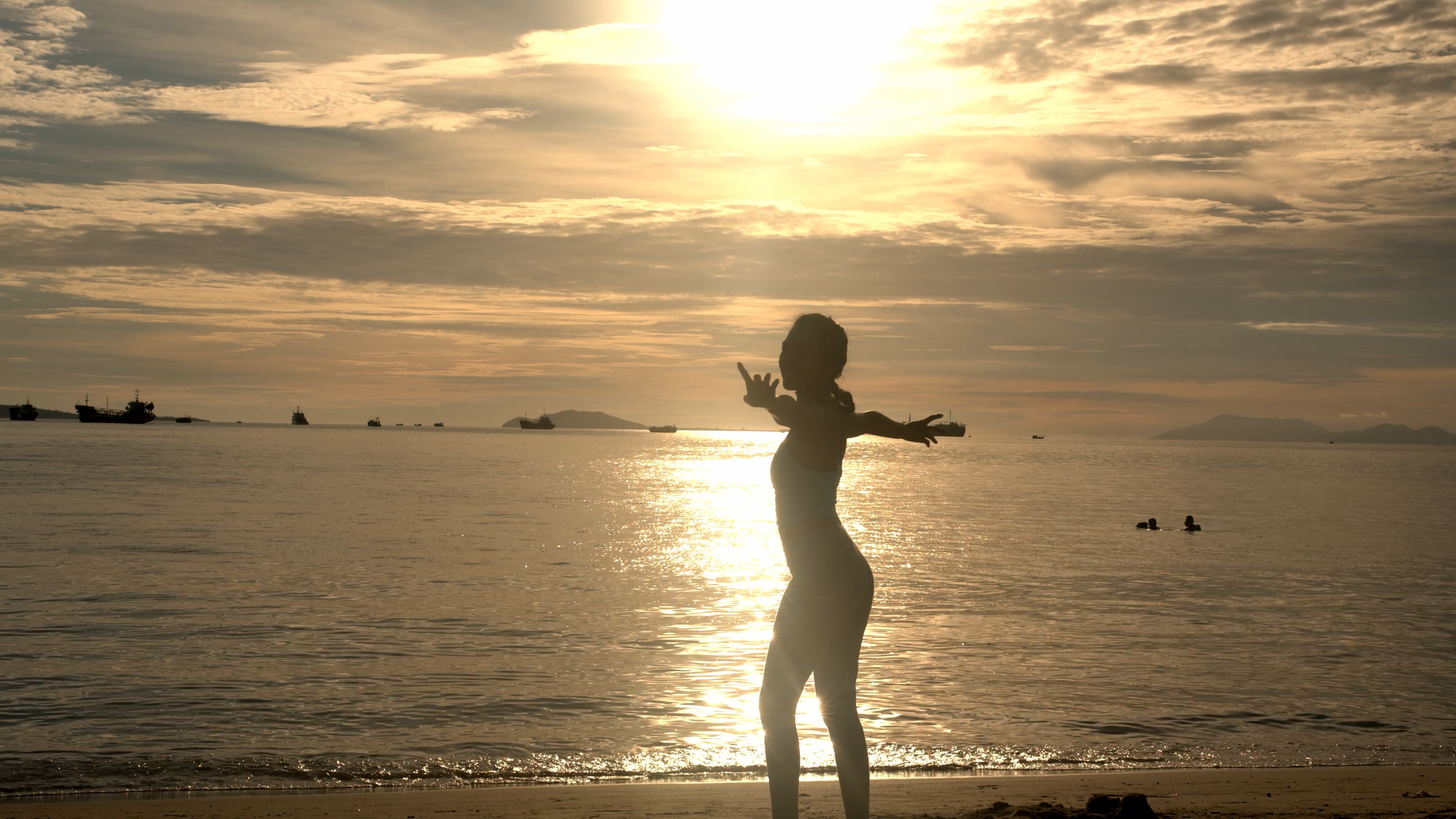 4K实拍夕阳下小姐姐在沙滩跳舞视频素材视频的预览图