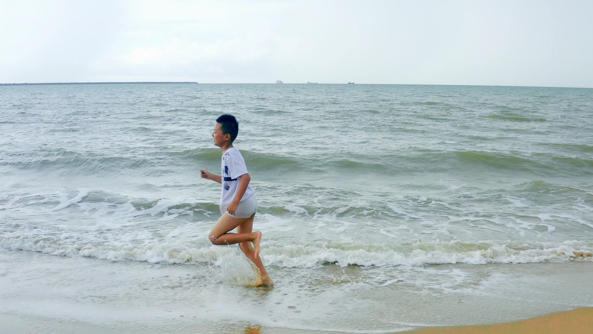 4K实拍沿着海边奔跑的小朋友视频素材视频的预览图