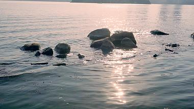 4K实拍湖边夕阳下的的石头水波视频空镜视频的预览图