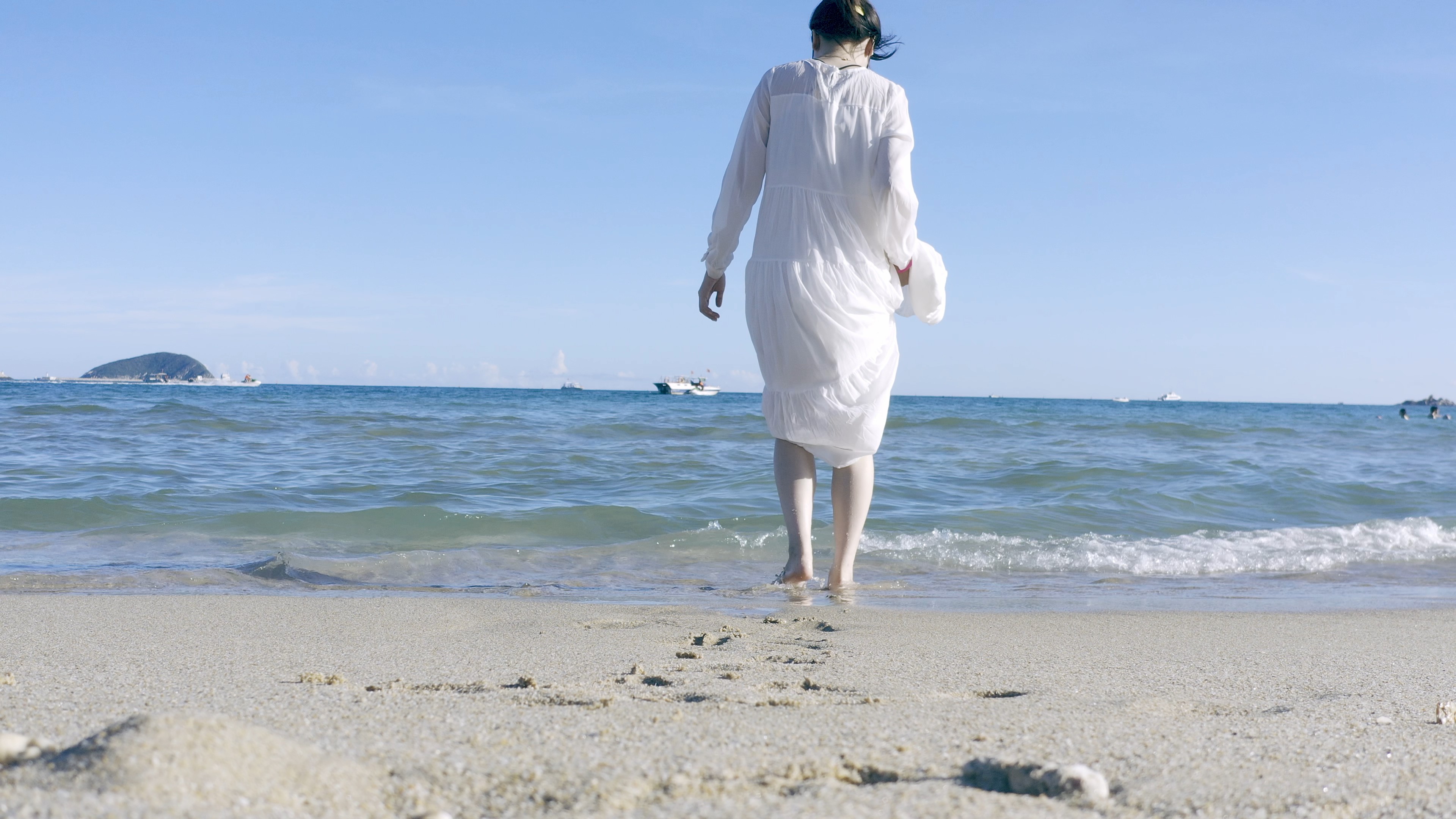 4K实拍海边美女背影走在沙滩上视频的预览图