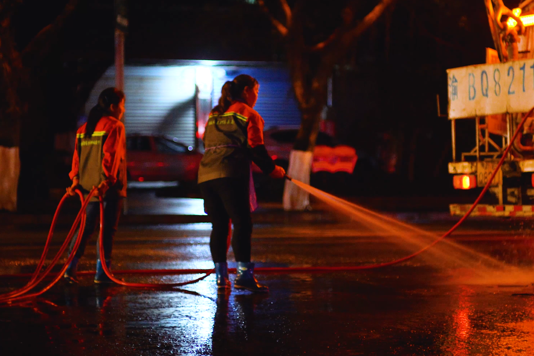 4K夜晚下的环卫工人清洁城市道路视频的预览图