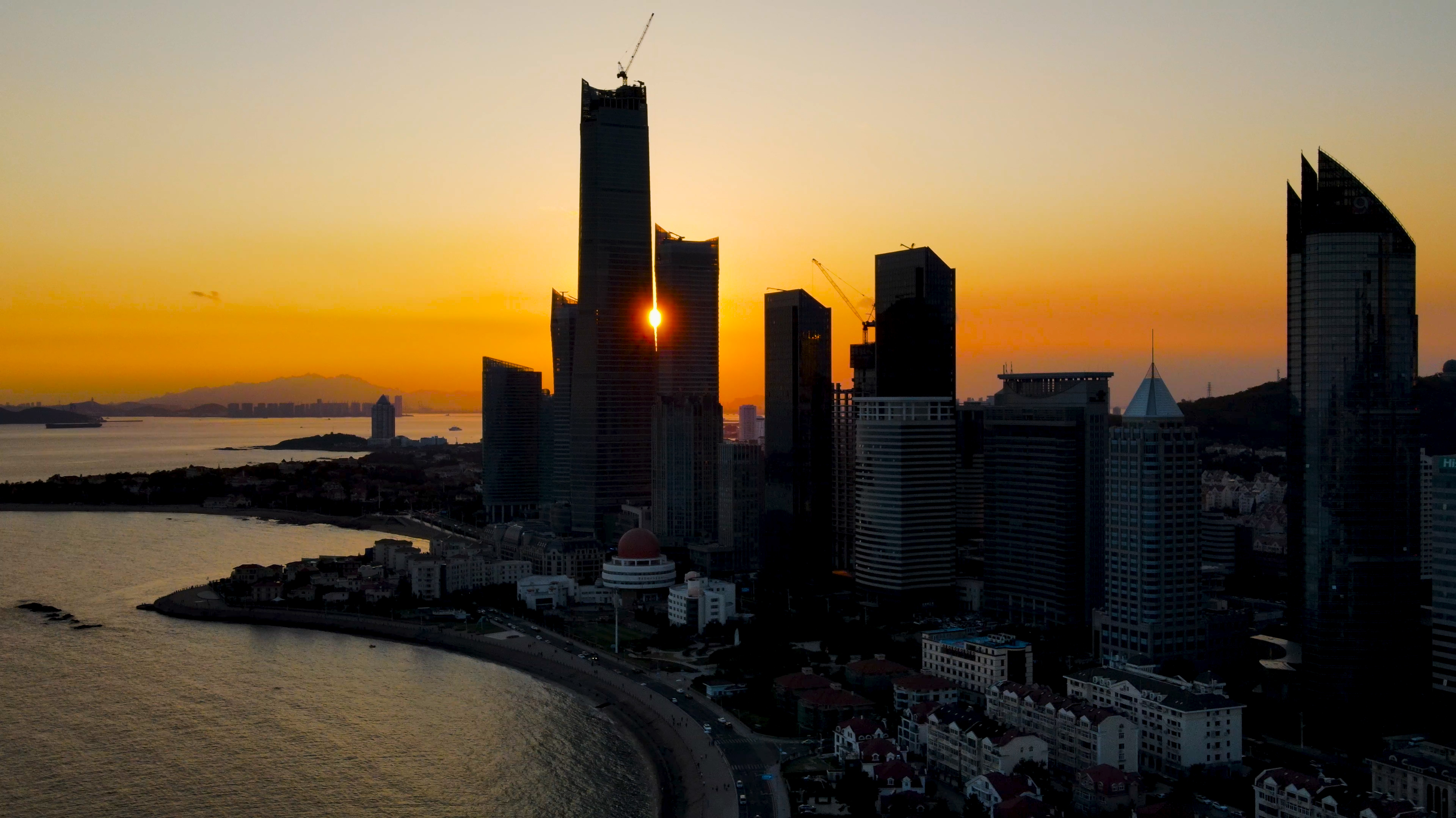 4K航拍实拍海边日落逆光高楼视频视频的预览图