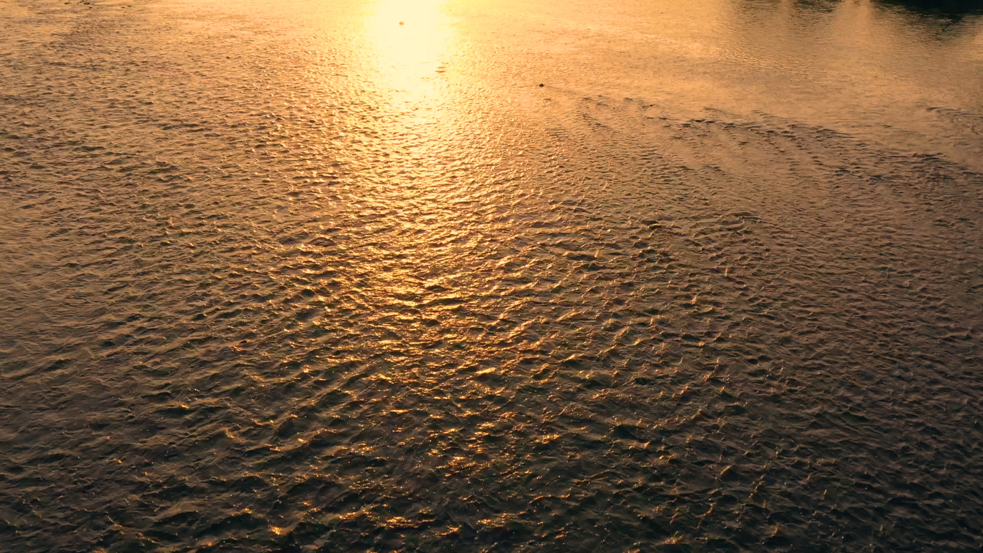 1080P航拍傍晚夕阳下水面波光粼粼的湖面空镜视频的预览图