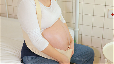 4k孕晚期的孕妇使用托腹带托住怀孕的肚子视频的预览图