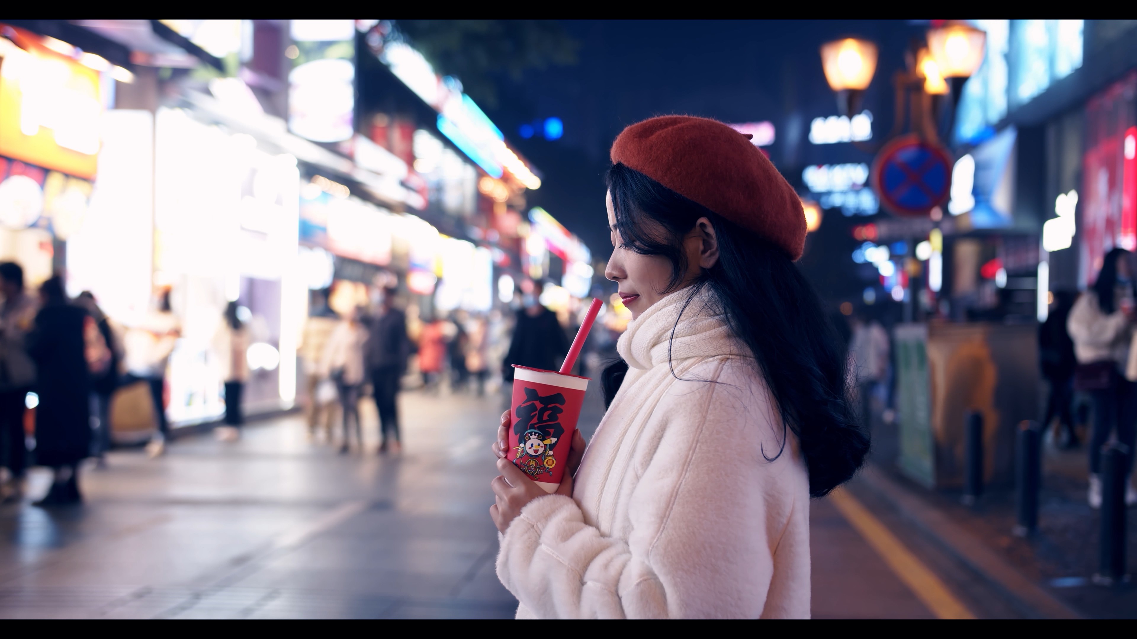 4K实拍夜晚美女拿着新年奶茶看着镜头微笑视频的预览图