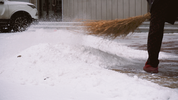 4K冬天女人扫雪除雪扫积雪视频视频的预览图