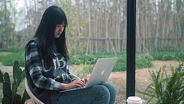 4K实拍美女坐在落地窗前使用电脑办公视频的预览图
