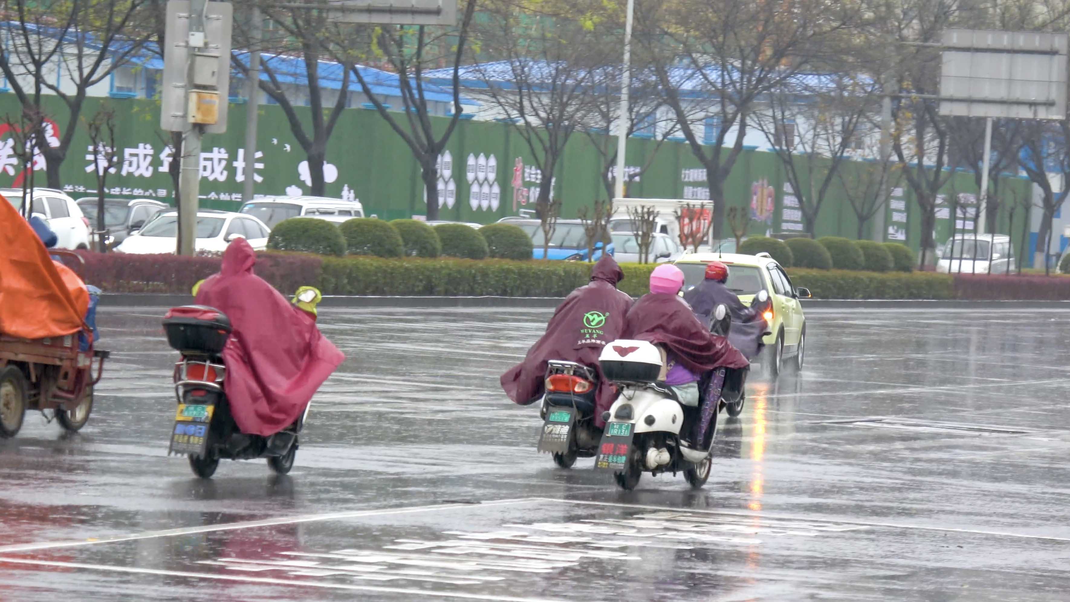 4k实况下雨天骑着电单车路口等待红绿灯的人们新闻素材视频视频的预览图