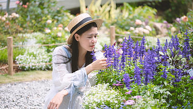 4K花丛中赏花的美丽少女人像视频视频的预览图