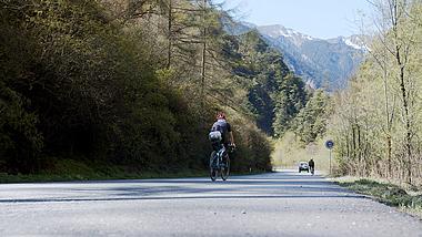 4K实拍森林的公路上骑自行车的人视频的预览图
