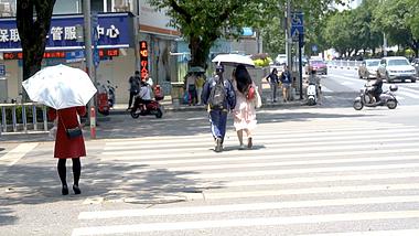 4k实拍夏天炎炎夏日的午后撑伞走路过马路的女孩子视频的预览图