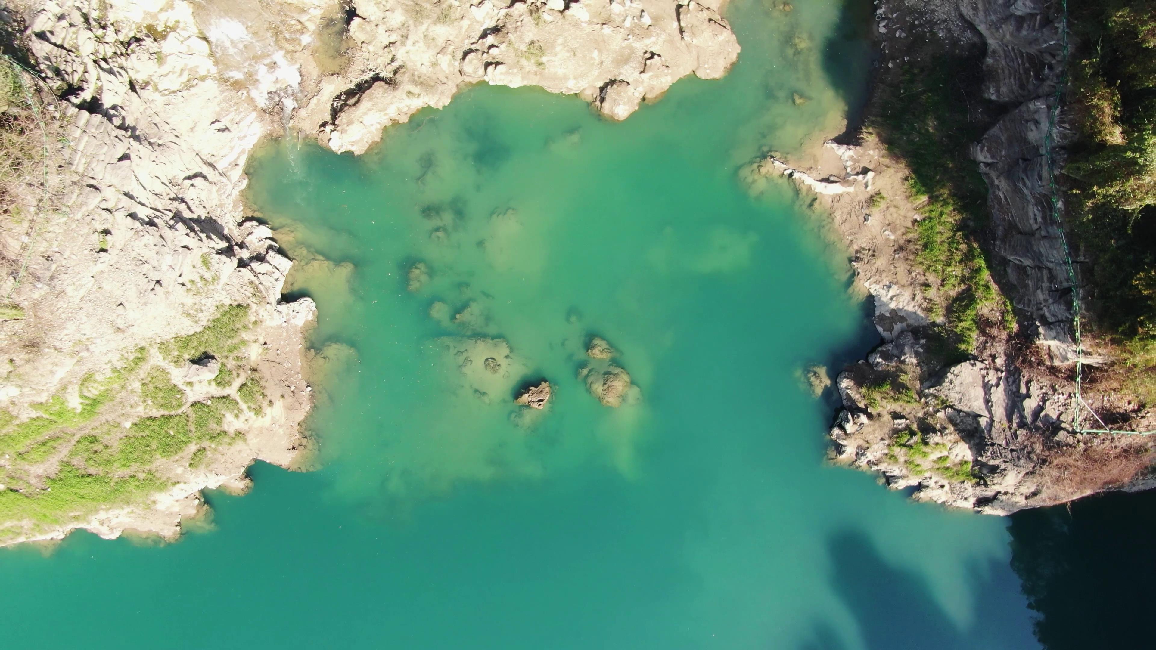 4K俯拍山谷悬崖蓝色唯美湖面自然风景视频的预览图