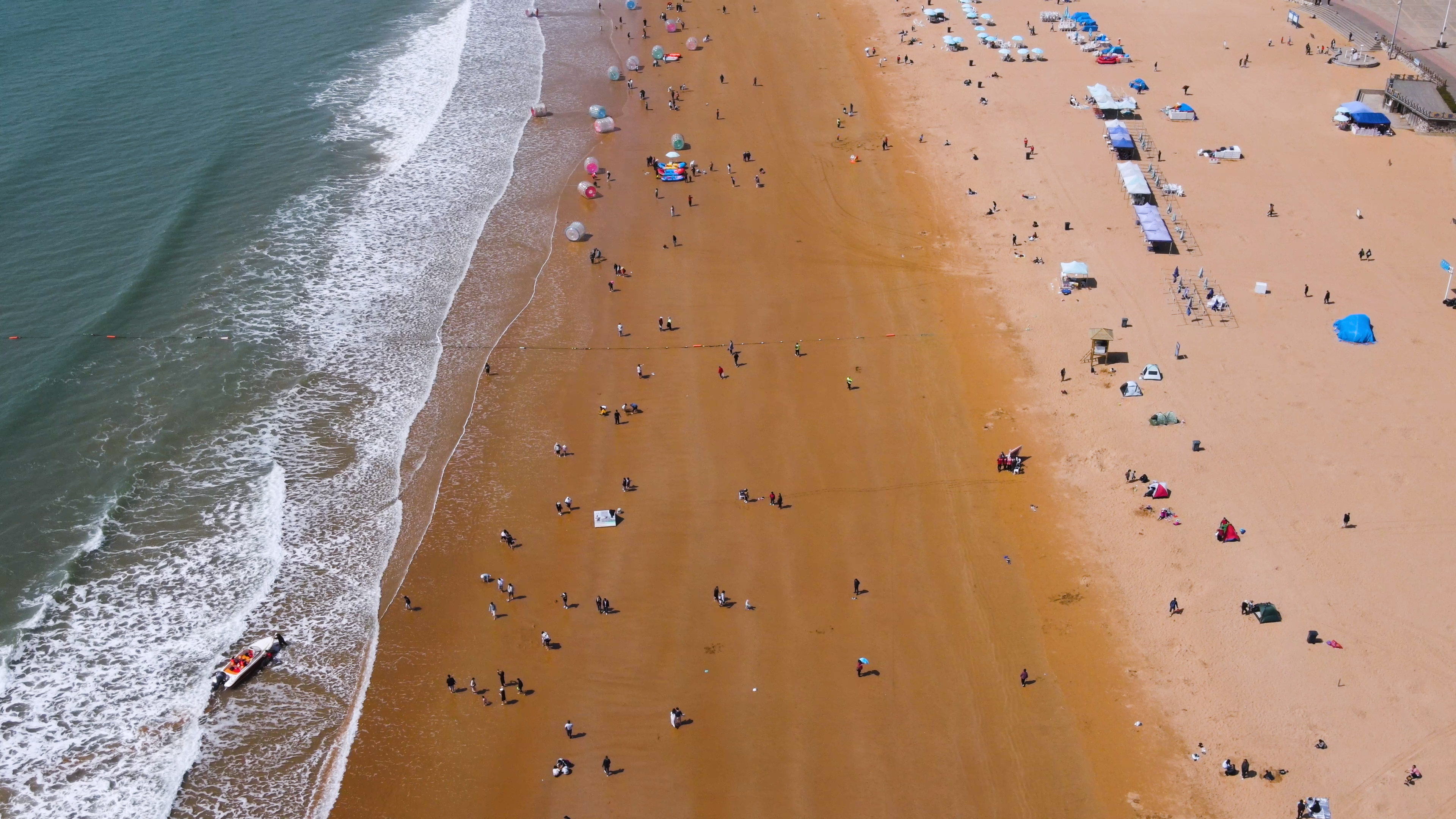 4K航拍夏天海边沙滩游玩的人群视频的预览图