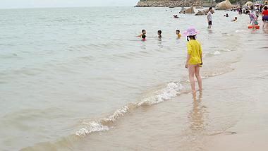 4K海边沙玩耍小女孩背影视频素材视频的预览图