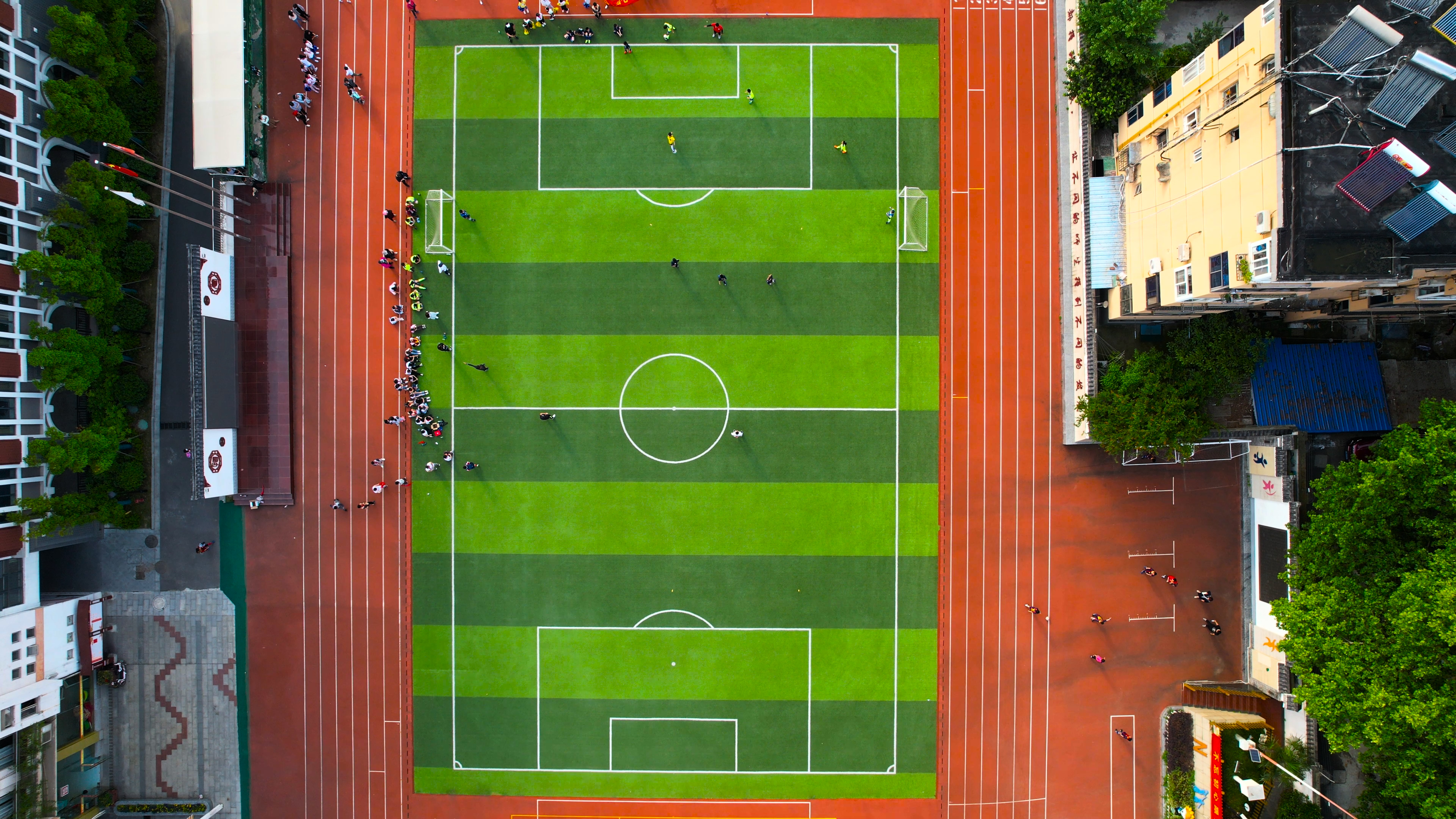 4K航拍学校操场足球场学生踢足球视频的预览图