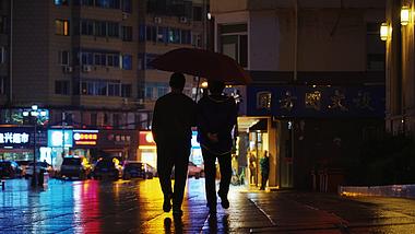 4k夜晚下雨行人打伞走路背影实拍视频的预览图