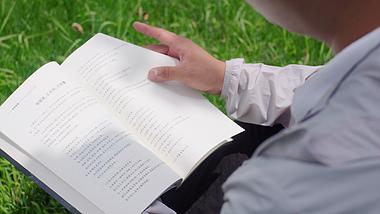4K实拍坐在草地上看书翻书阅读的休闲时光空镜视频的预览图