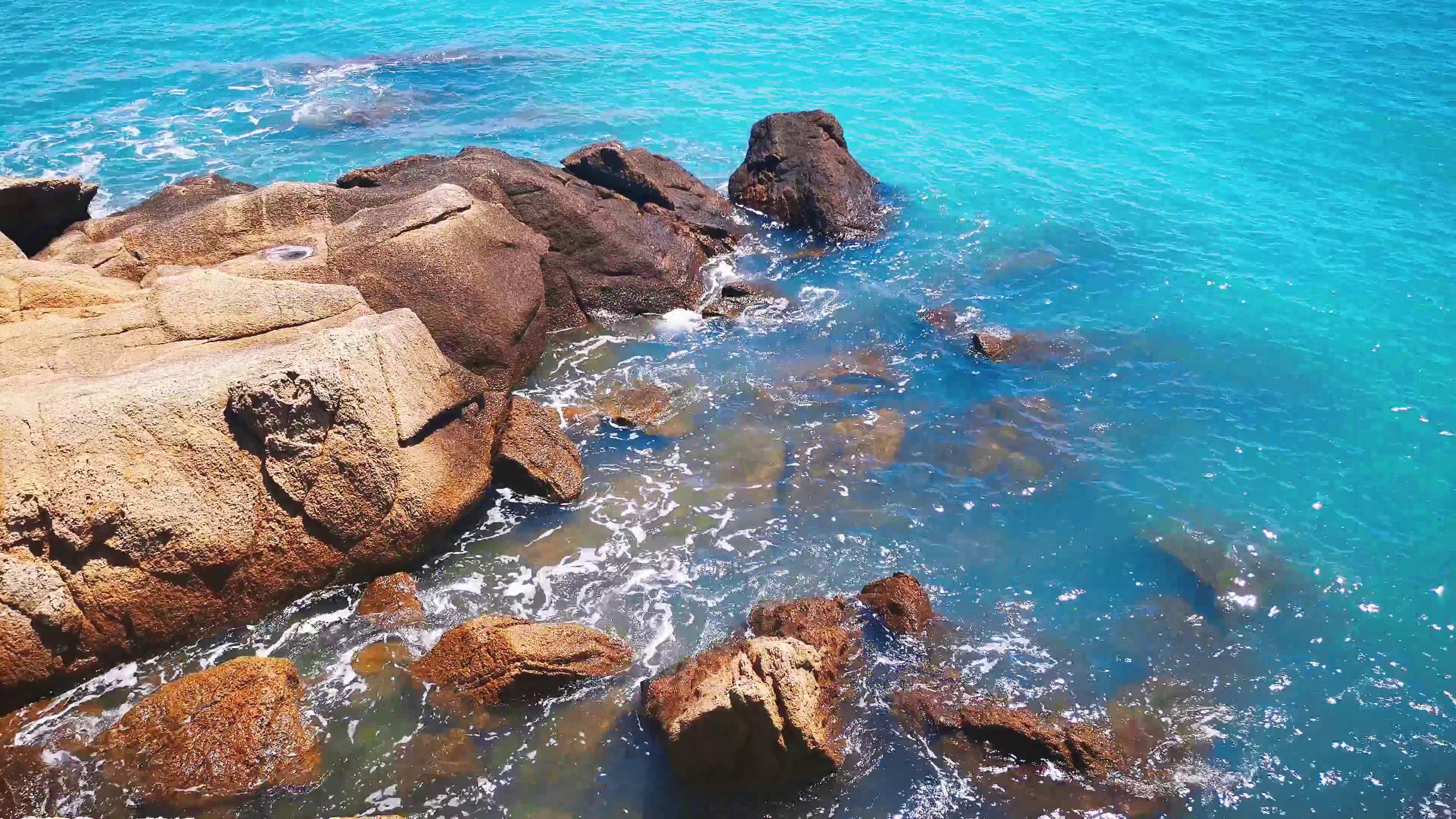 4K实拍蔚蓝的海水河岸的礁石自然风景视频视频的预览图