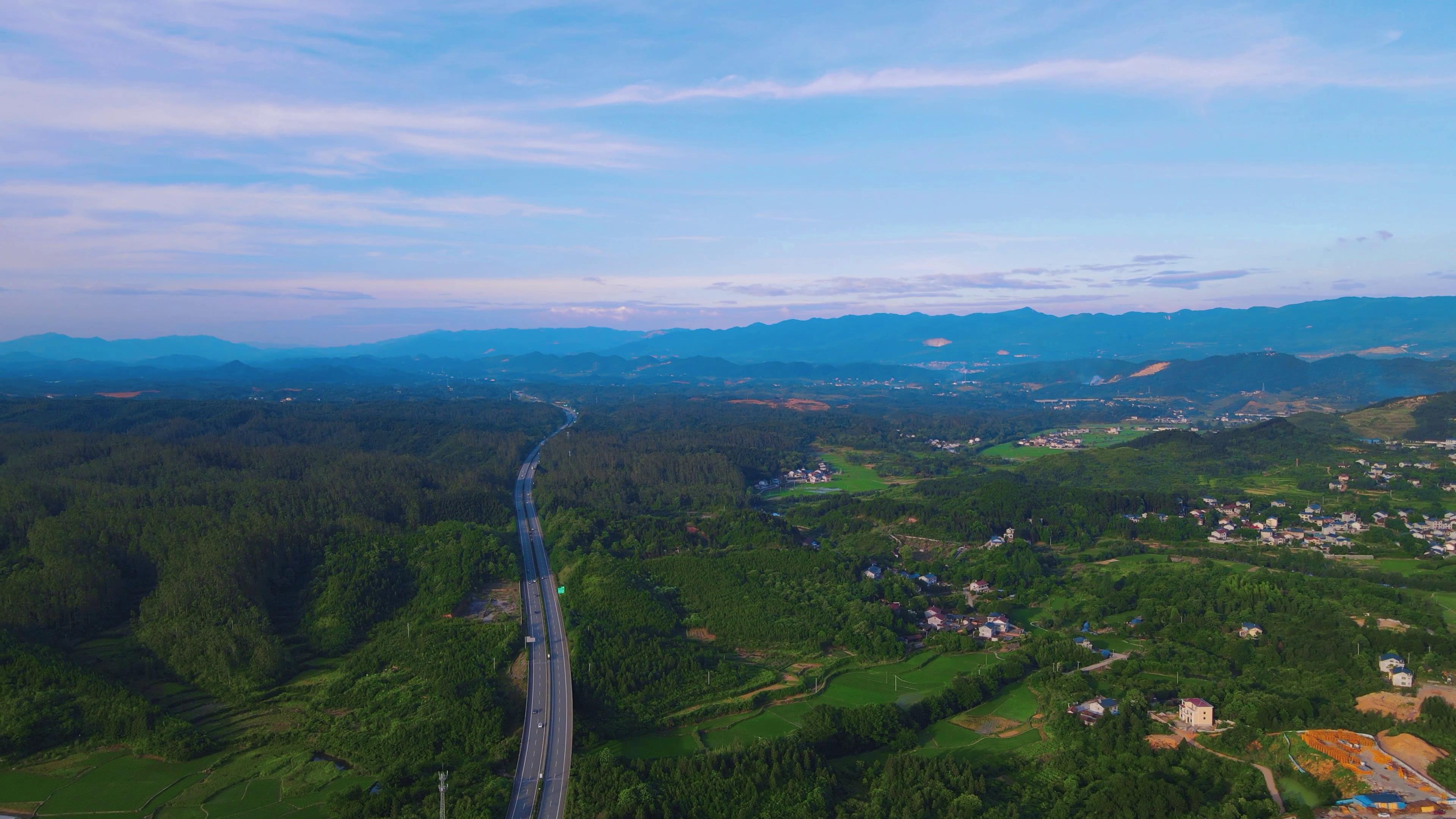 4K航拍乡村山川丘陵中的高速路交通视频视频的预览图
