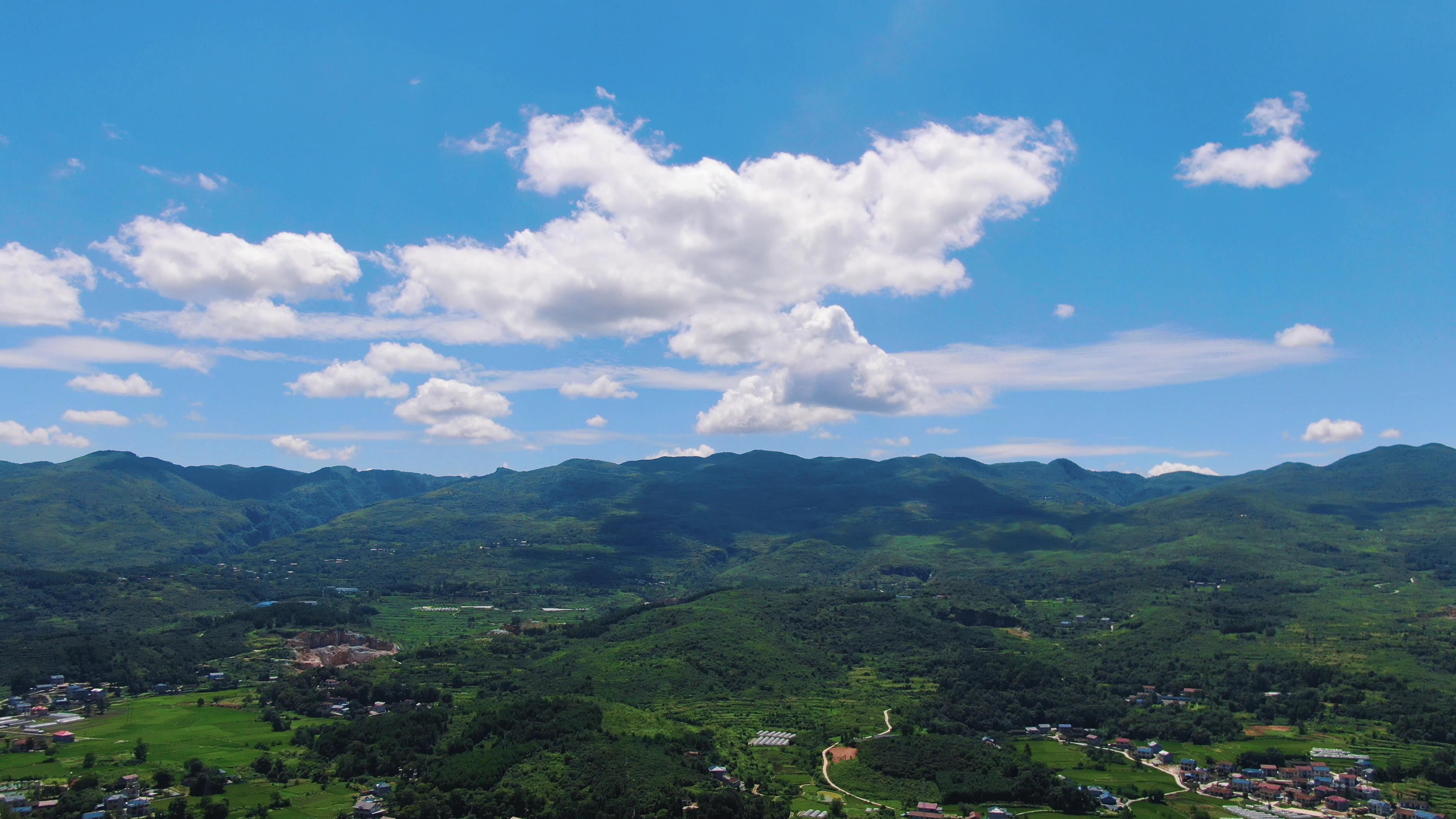4K航拍蓝天下连绵起伏的山峰云朵山脉自然风景视频的预览图
